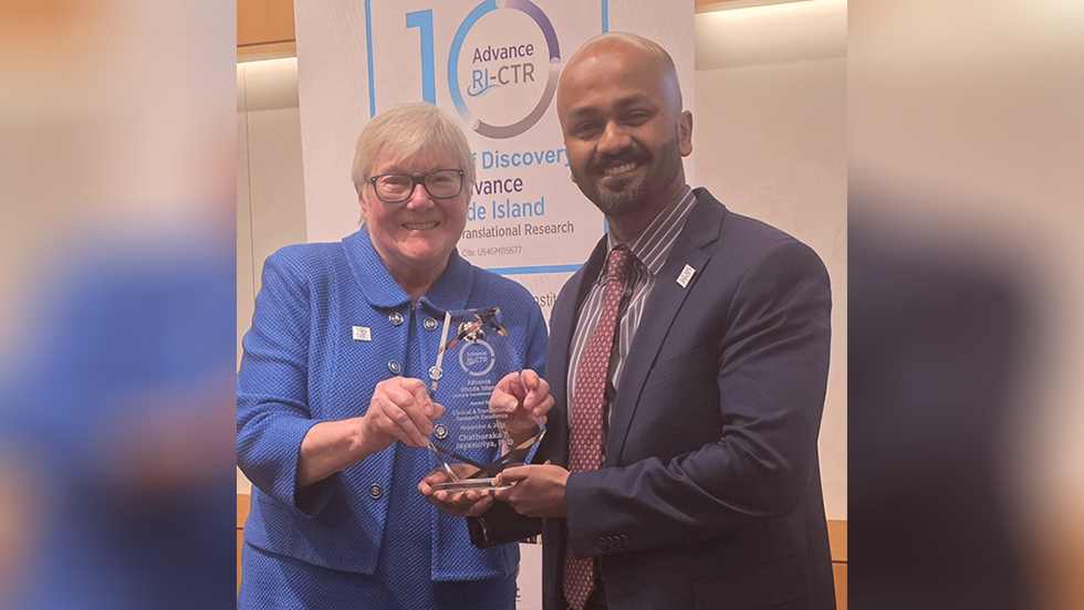 two people posing for a photo and holding an award