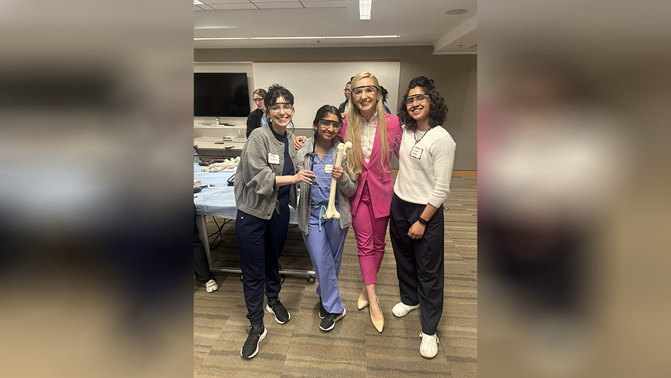 four residents in PPE holding a bone
