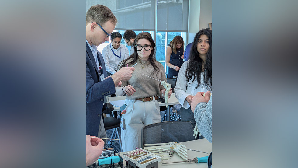 instructor showing students a bone model