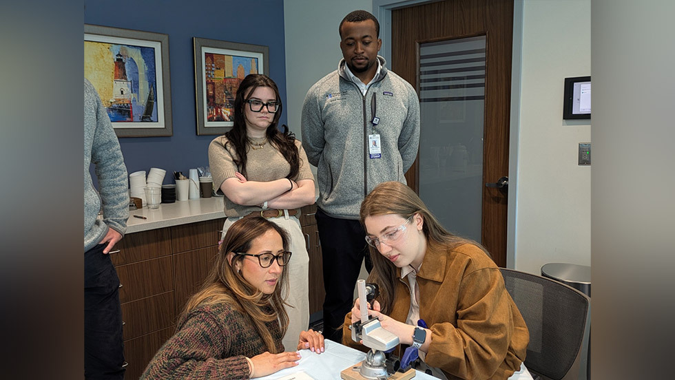 two people working with a model while two others watch