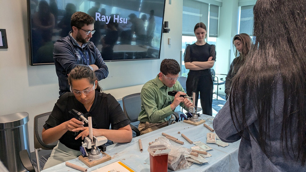 people building things at a table while others watch