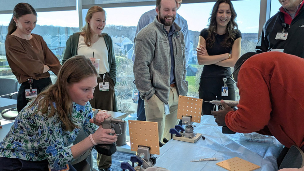 two people drilling into squares while several people watch