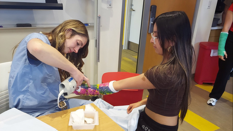 medical student taking a cast off a young patient